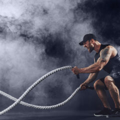 Muškarac u teretani vježba s battle užetom – fitness trening snage i izdržljivosti